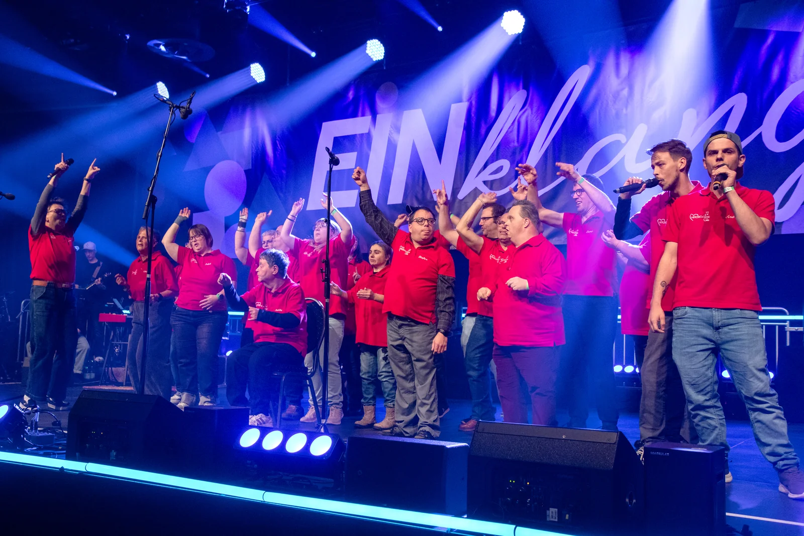 Begeisterte Musikgruppe mit erhobenen Armen bei EINklang 2026.