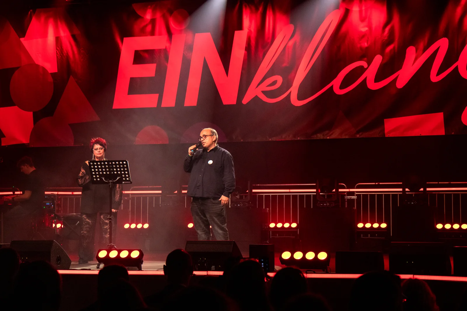 Gesangsduo auf der rot beleuchteten Bühne des EINklang-Festivals.
